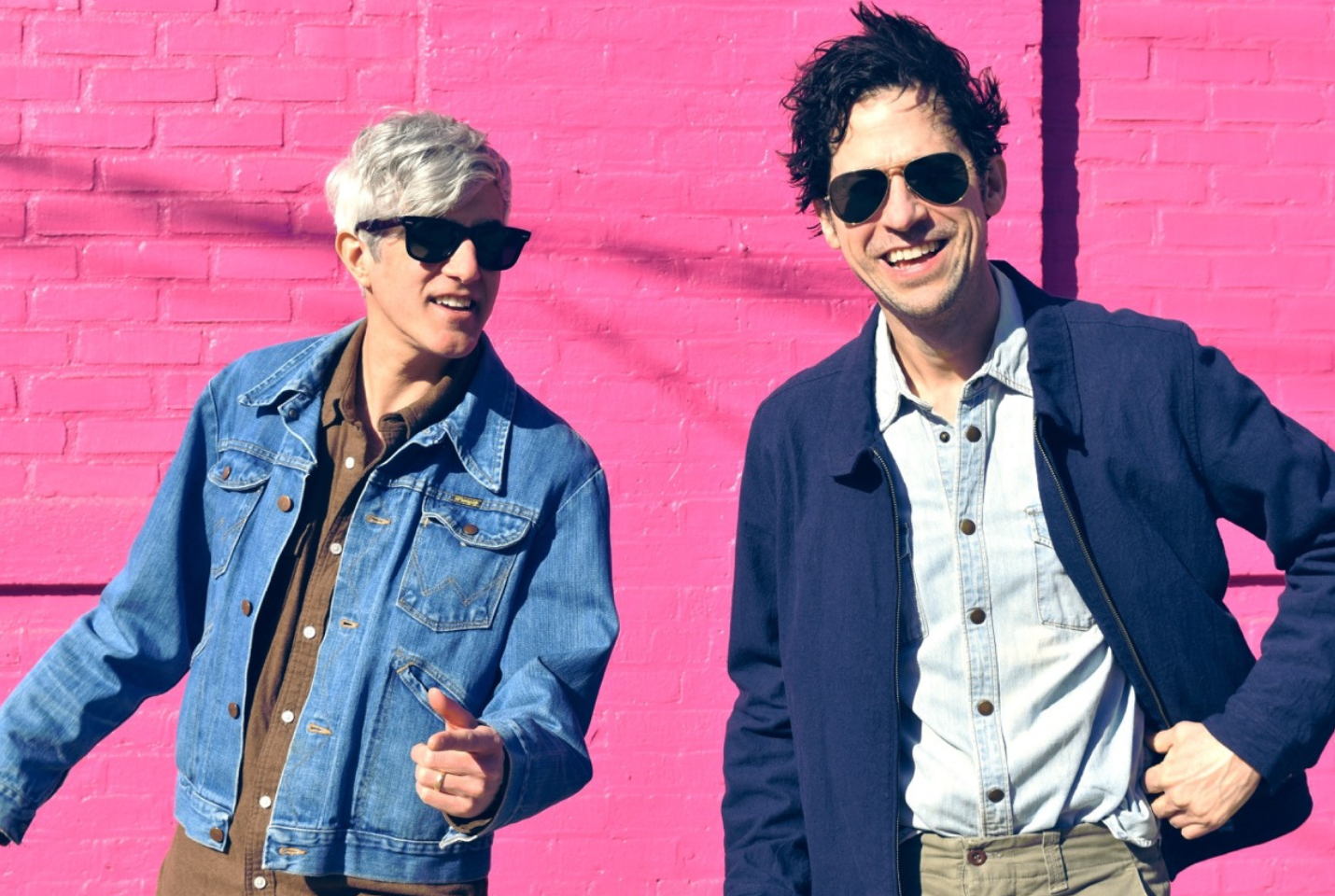 Band We Are Scientists press shot - smiling infront of pink wall